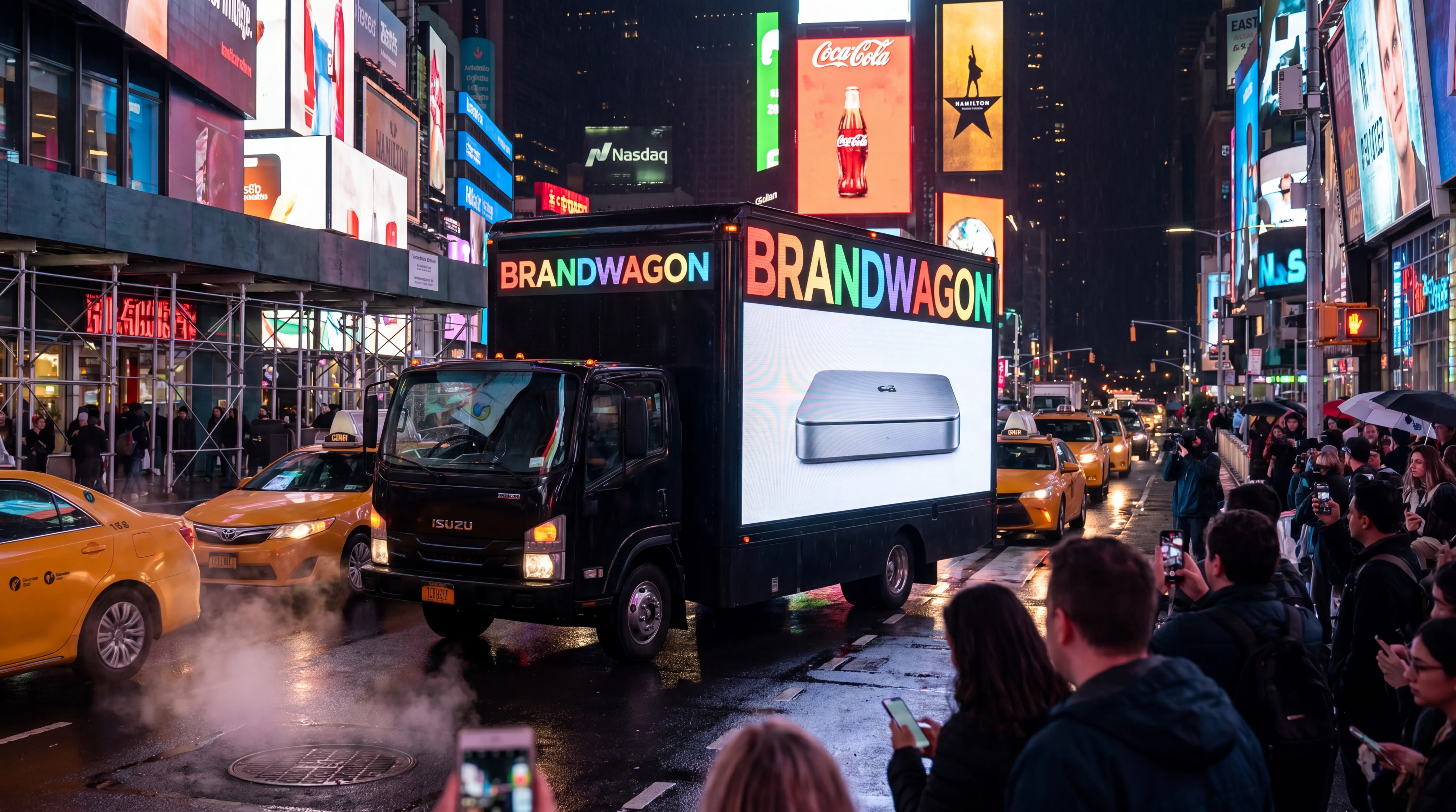 Brandwagon truck inching through Times Square at night surrounded by Coca-Cola, Hamilton, and Nasdaq billboards